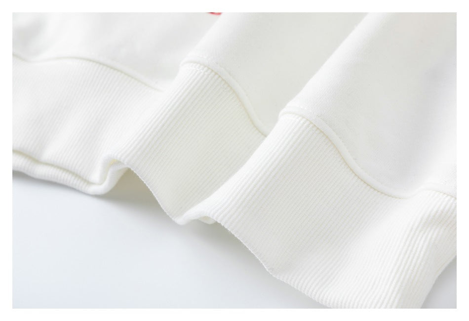 Close-up of wide ribbed white sweatshirt cuffs and finished edges.
