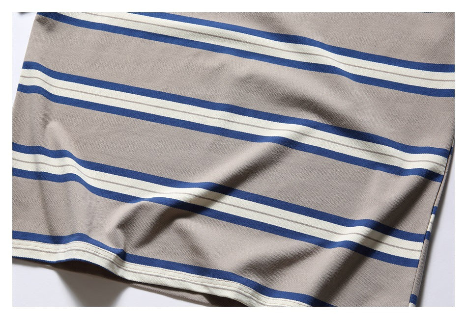 Cropped view of beige-gray fabric with repeating blue and white horizontal stripes and visible folds.