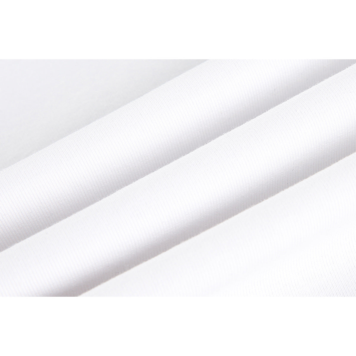 Extreme close-up of white ribbed knit fabric folded into soft diagonal ridges.