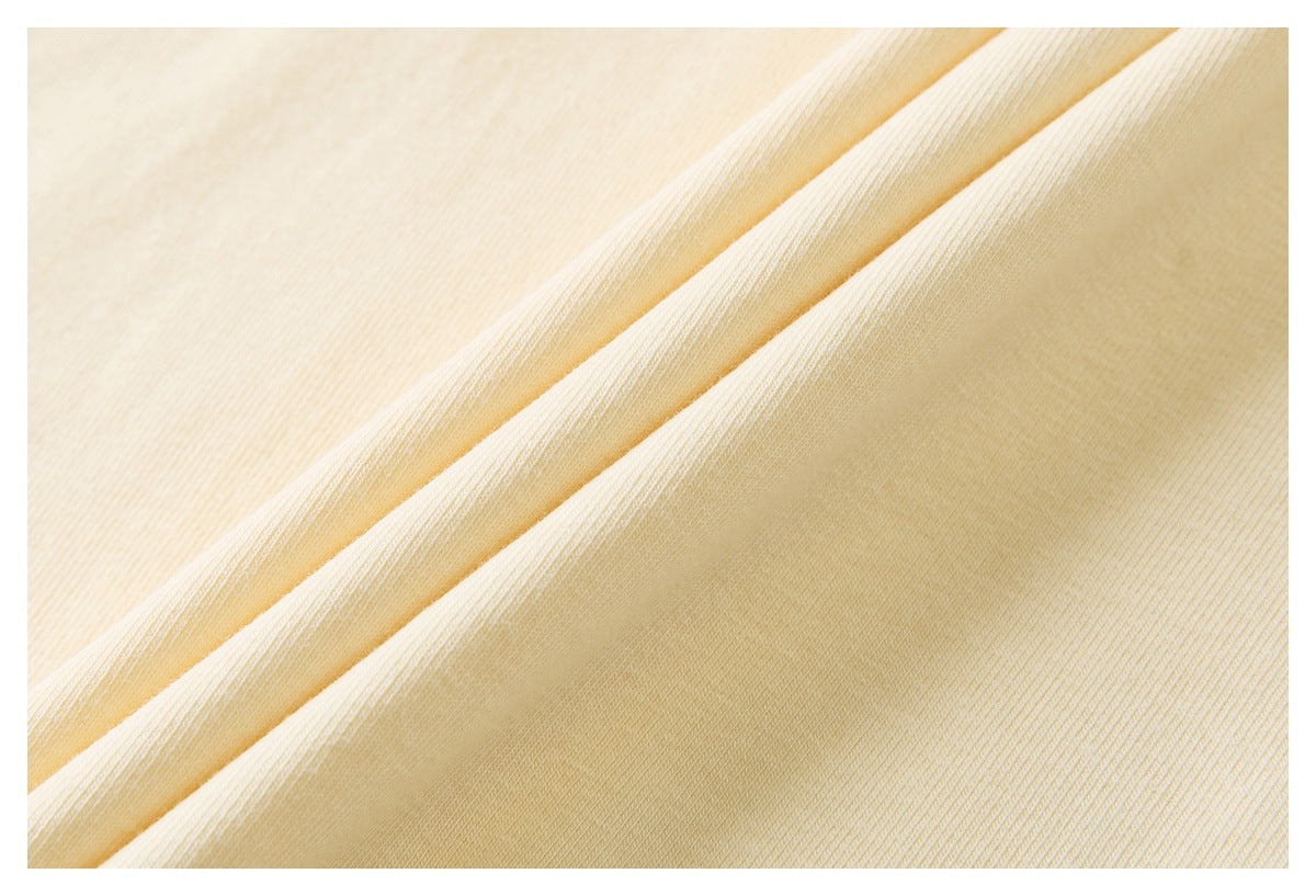 Close-up of cream-colored fabric folded to show its fine, diagonal knit texture.