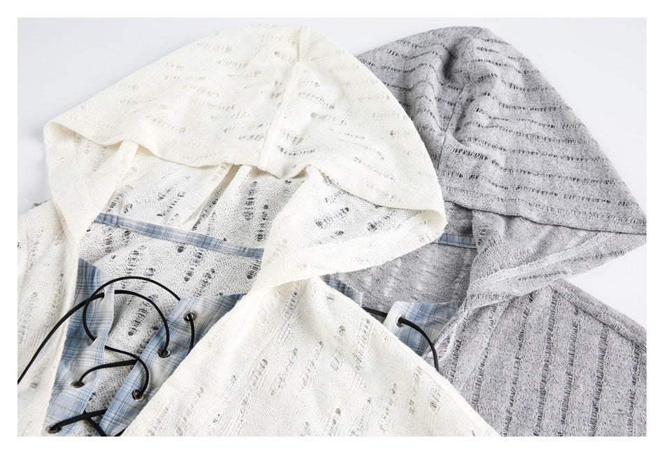 White and gray hooded garments arranged together, with open-knit stripes and plaid panels at the lace-up fronts.