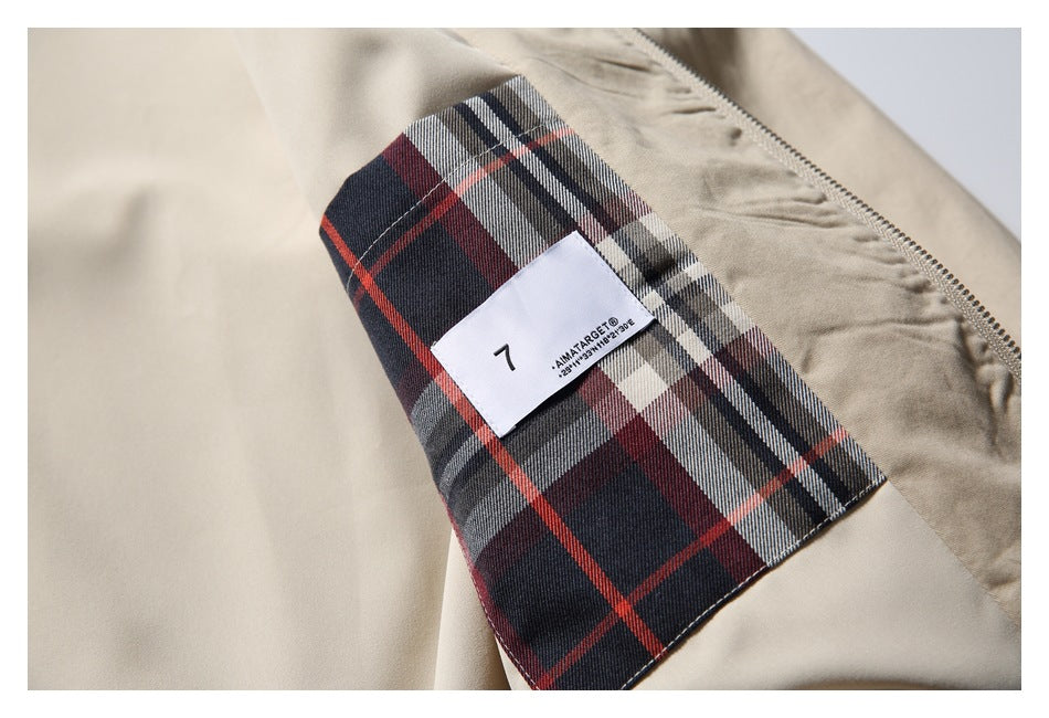 Close-up of the beige jacket's red, navy and gray plaid lining with a sewn-in label.