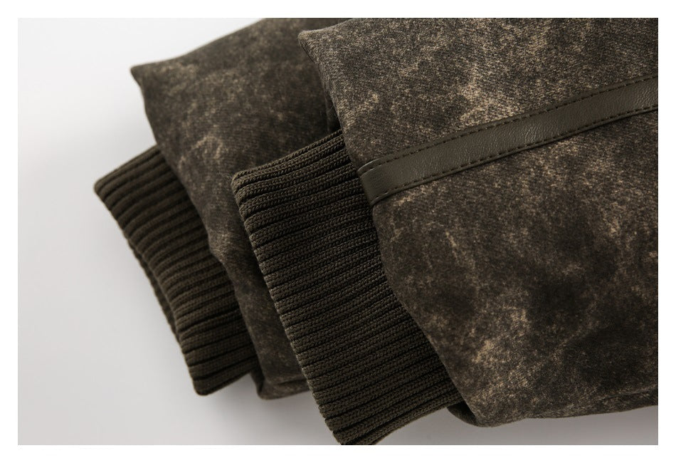 Close-up of dark rib-knit cuffs and a narrow leather-like trim on a mottled brown jacket.