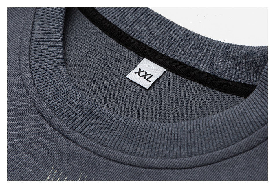 Close-up of a charcoal sweatshirt's ribbed crew neckline and inner label marked XXL.