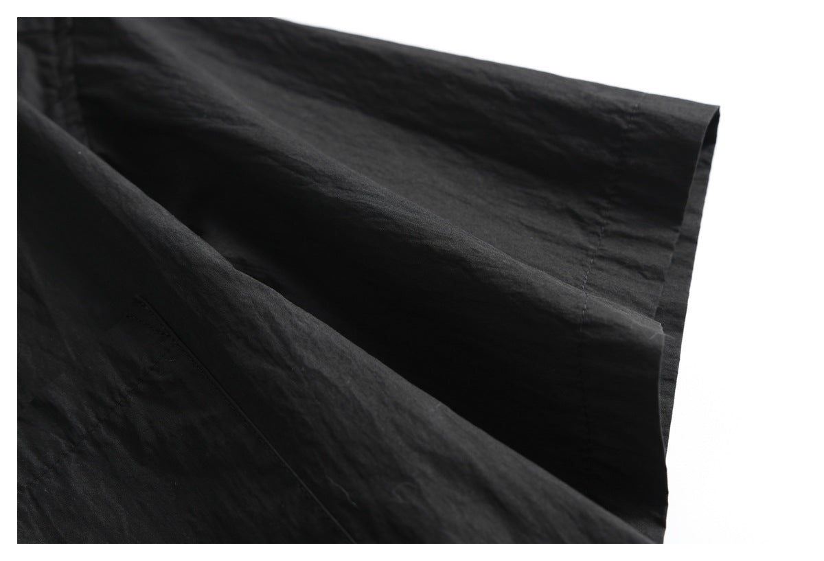 Close-up of the short sleeve and hem on a black shirt.