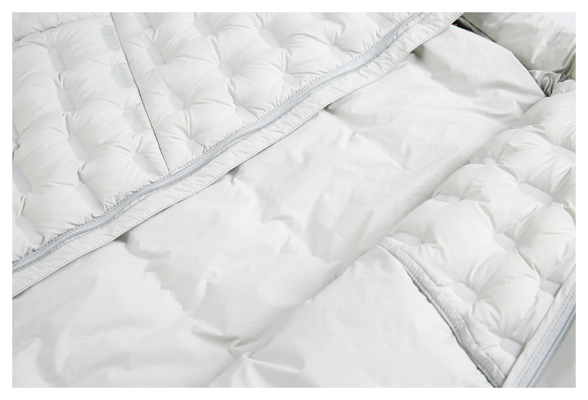 Close-up of a pale gray padded jacket interior with quilted sections and a zipper edge.