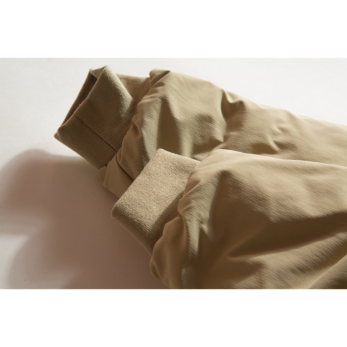 Close-up of a tan jacket sleeve with a ribbed cuff.
