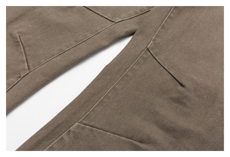 Close-up of taupe trouser legs showing seams, stitching and fabric texture.