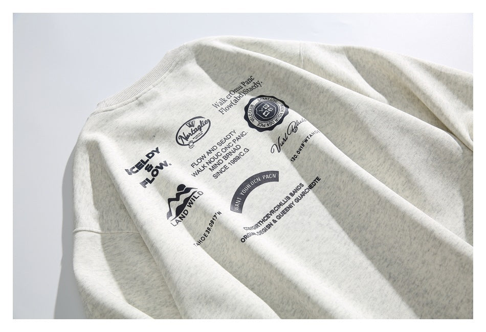Flat-lay view of a heathered light-gray sweatshirt with a crew neck and multiple dark printed graphics across the chest.
