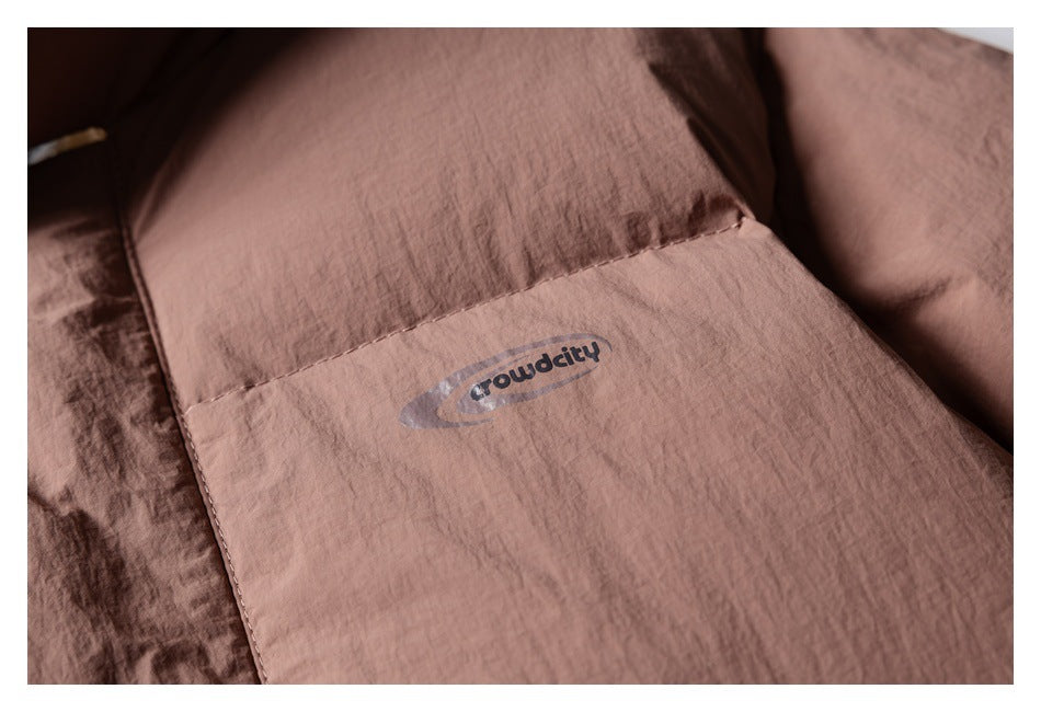Close-up of a small printed logo on a panel of the dusty rose jacket.
