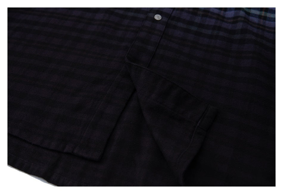 Close-up of the dark plaid shirt hem and overlapping fabric panels.