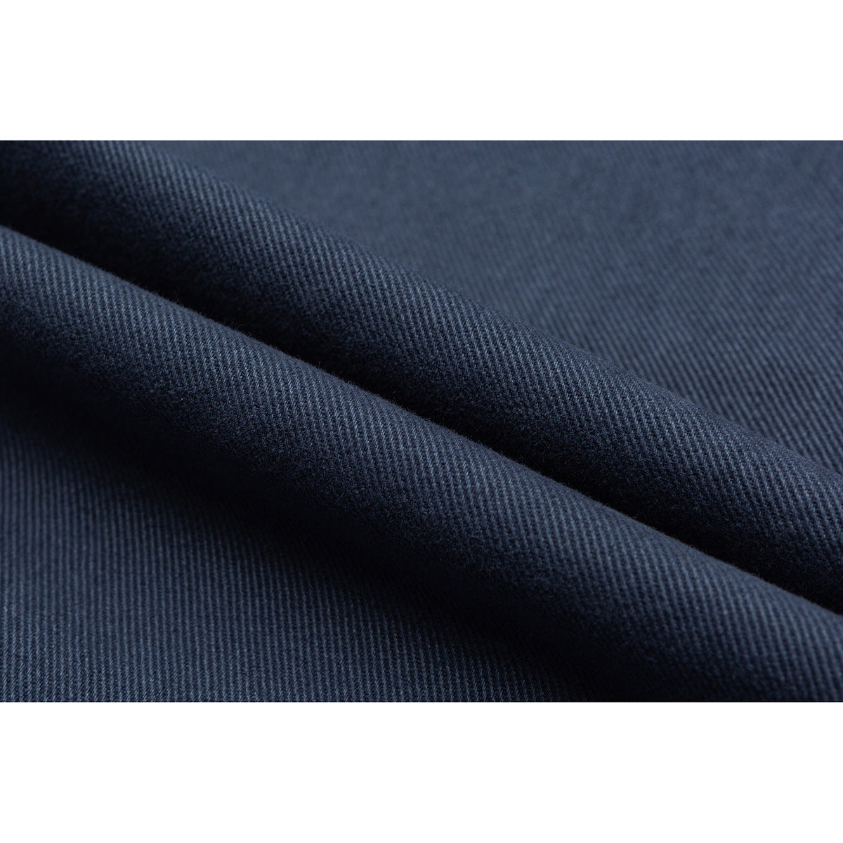 Close-up of dark blue fabric with a diagonal weave and soft folds.