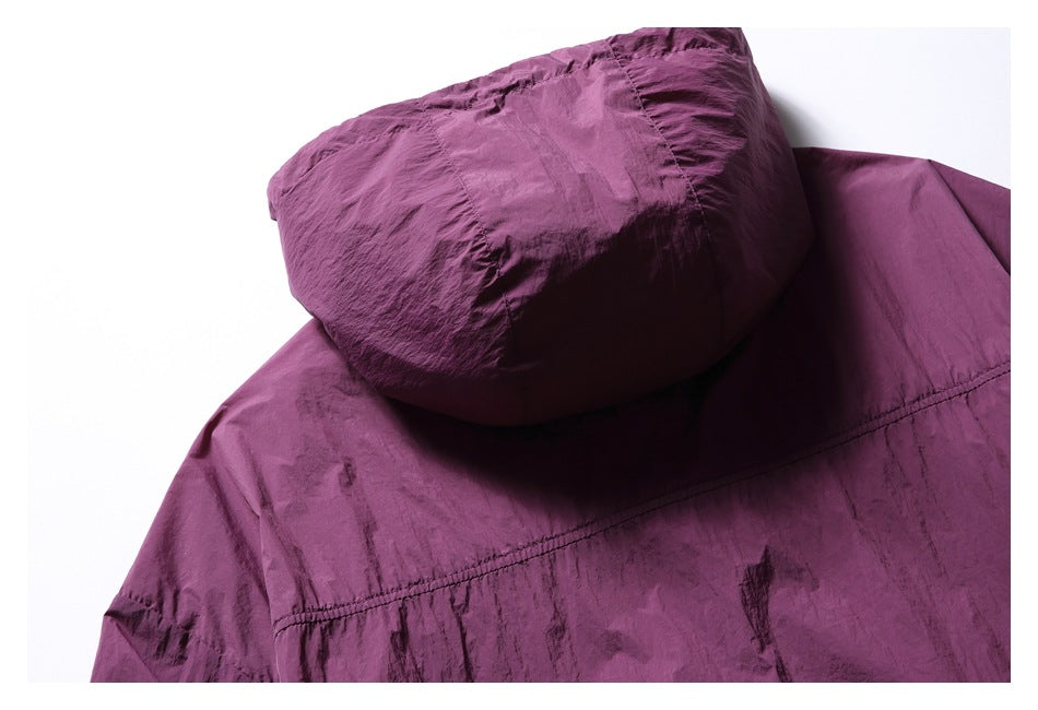 Close-up of the back of a plum jacket showing its hood and a horizontal stitched seam.