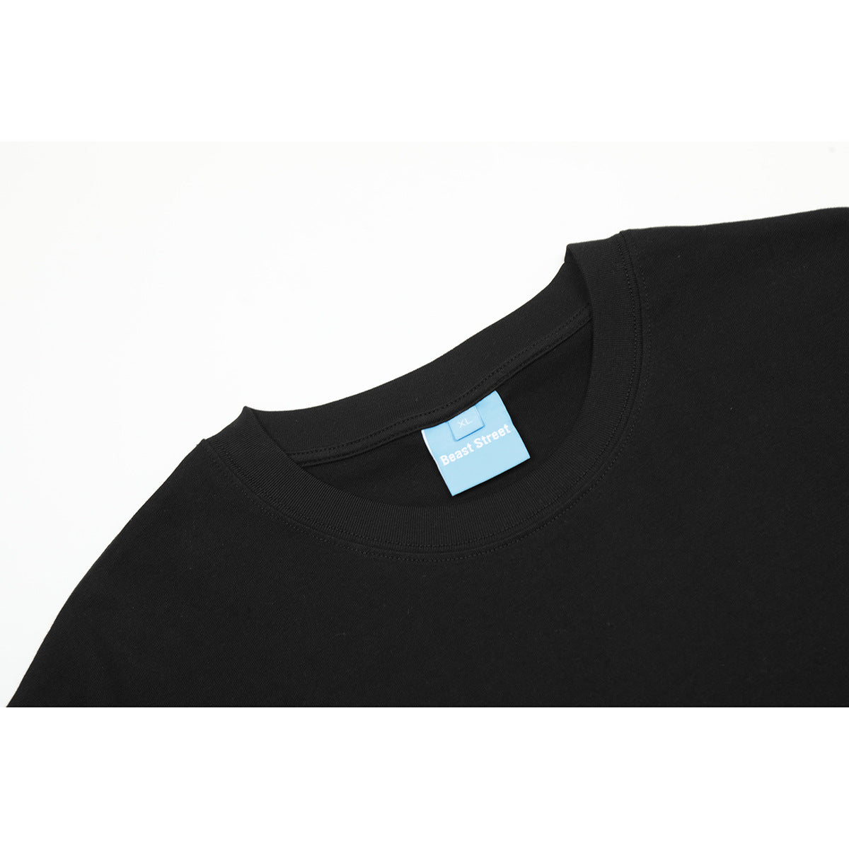 Close-up of a black T-shirt crew neck with a blue Beast Street XL label.