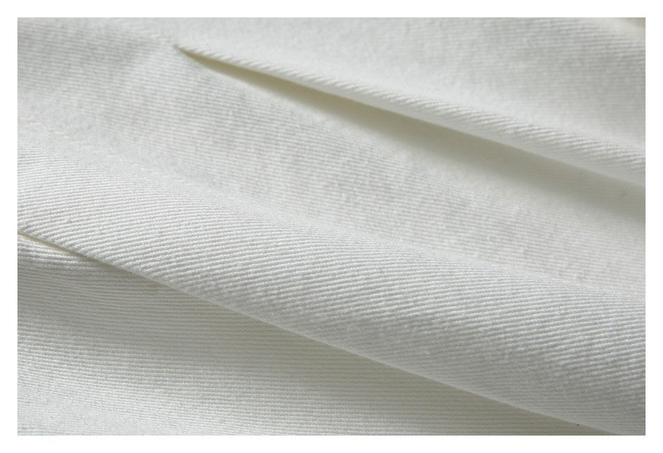 Close-up of overlapping white fabric panels showing a fine diagonal weave.