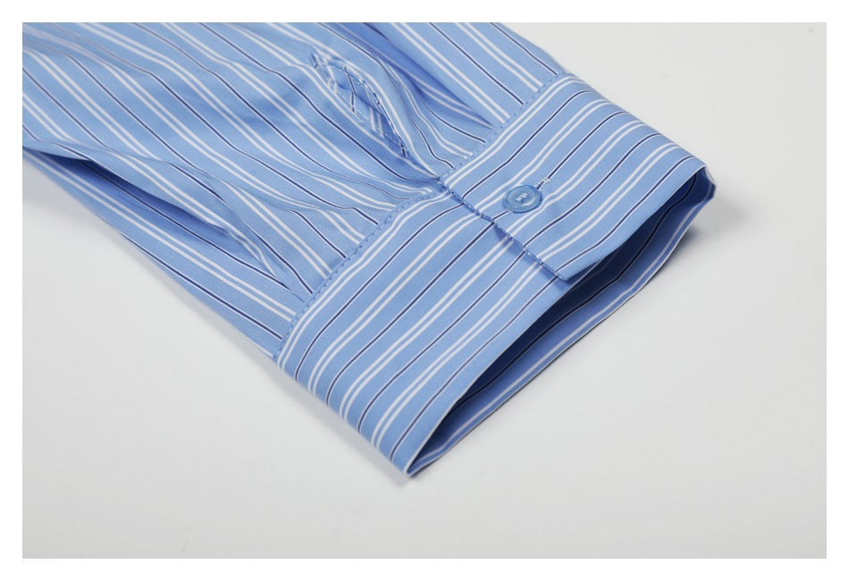 Close-up of the striped shirt cuff with a blue button and sleeve placket.