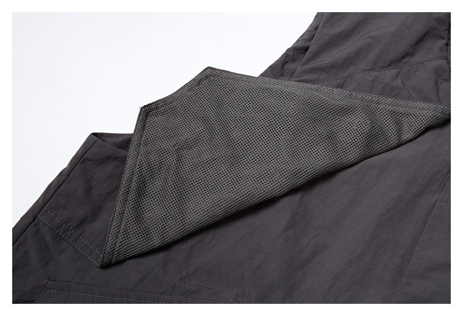Close-up showing a mesh lining panel inside the charcoal vest.