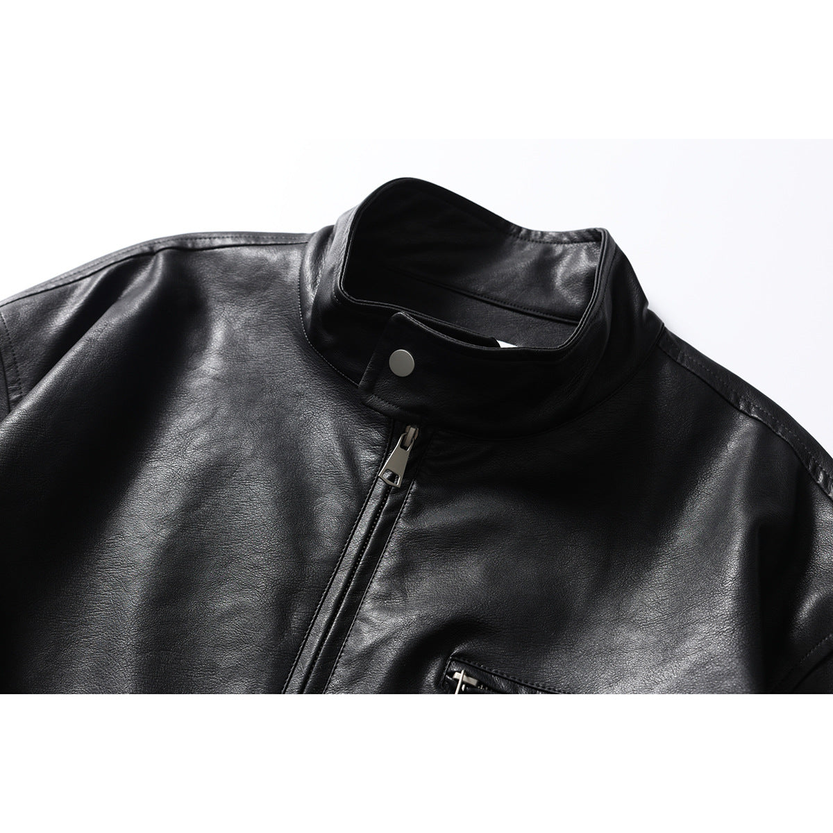 Close-up of a black jacket's stand collar, snap tab, front zipper, and upper chest.