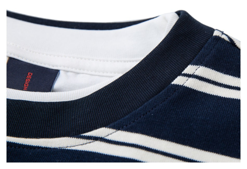 Close-up of the ribbed navy collar, white inner neckline, and garment label marked “DESIGN.”