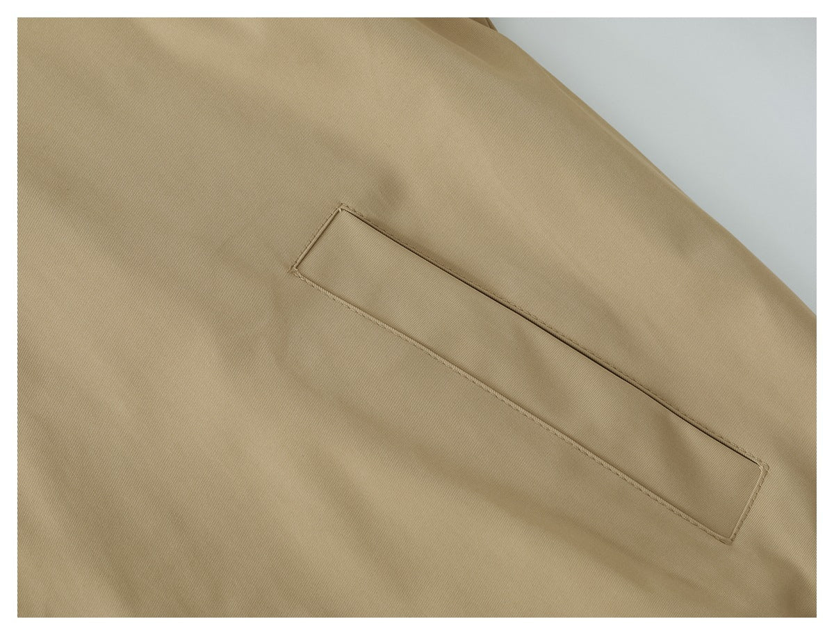 Close-up of a slim welt pocket stitched into the tan jacket.
