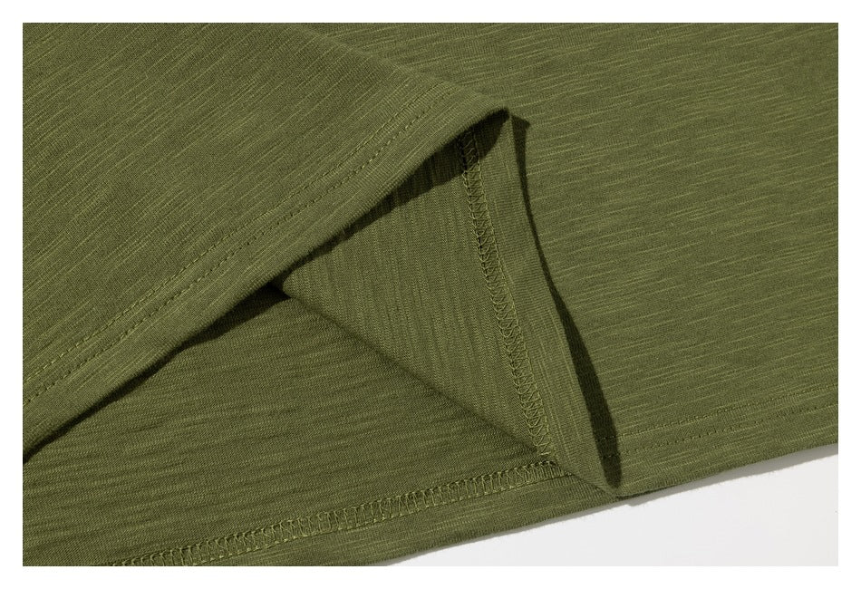 Close-up of the olive green T-shirt's stitched side seam and hem.