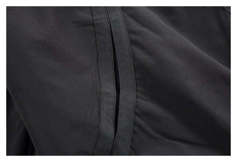 Close-up of black garment fabric with a narrow vertical stitched trim.