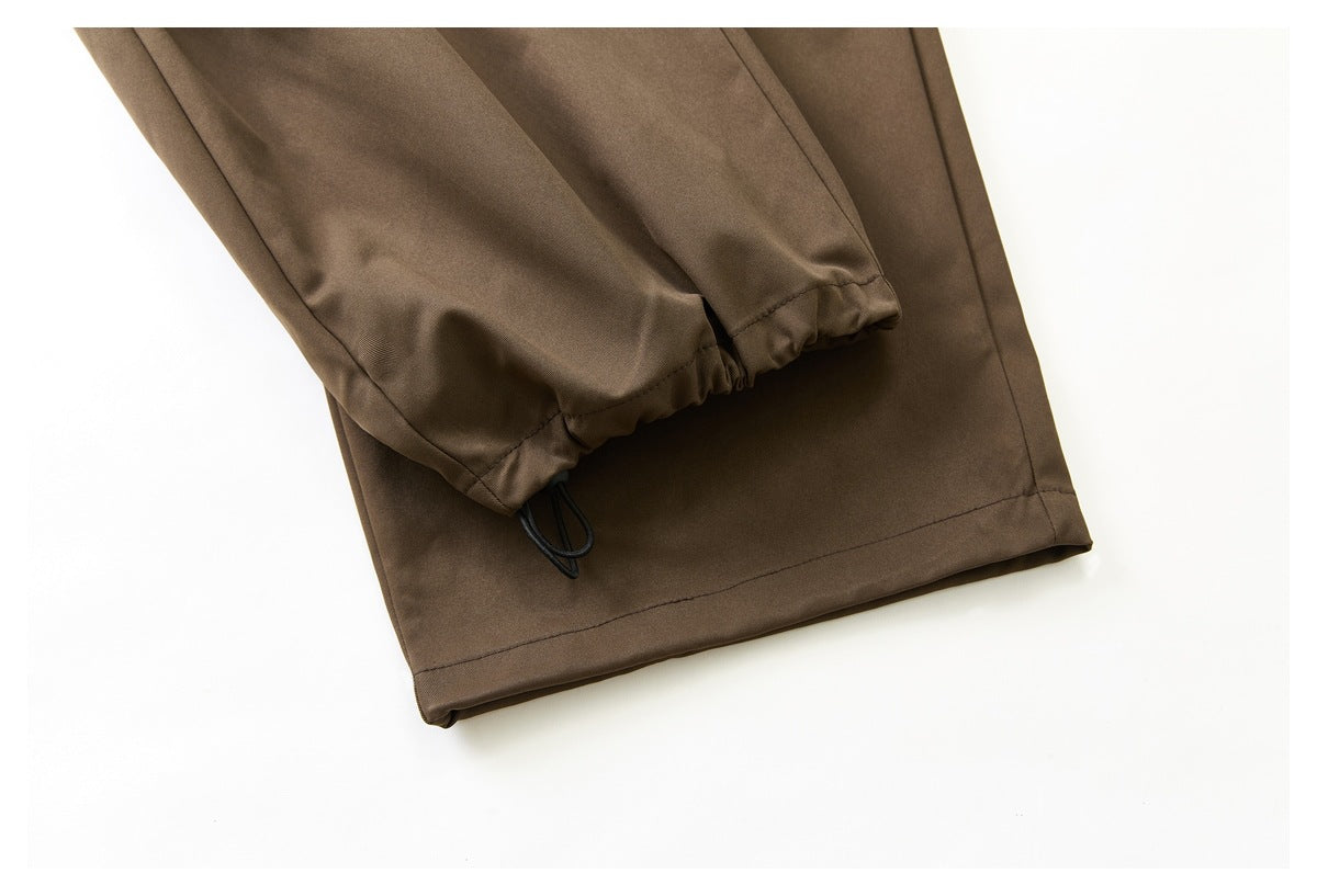 Close-up of a brown trouser leg with an elasticated cuff and black cord loop.