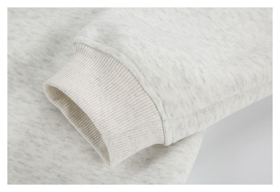 Close-up of a light gray heather sweatshirt sleeve ending in a wide rib-knit cuff.