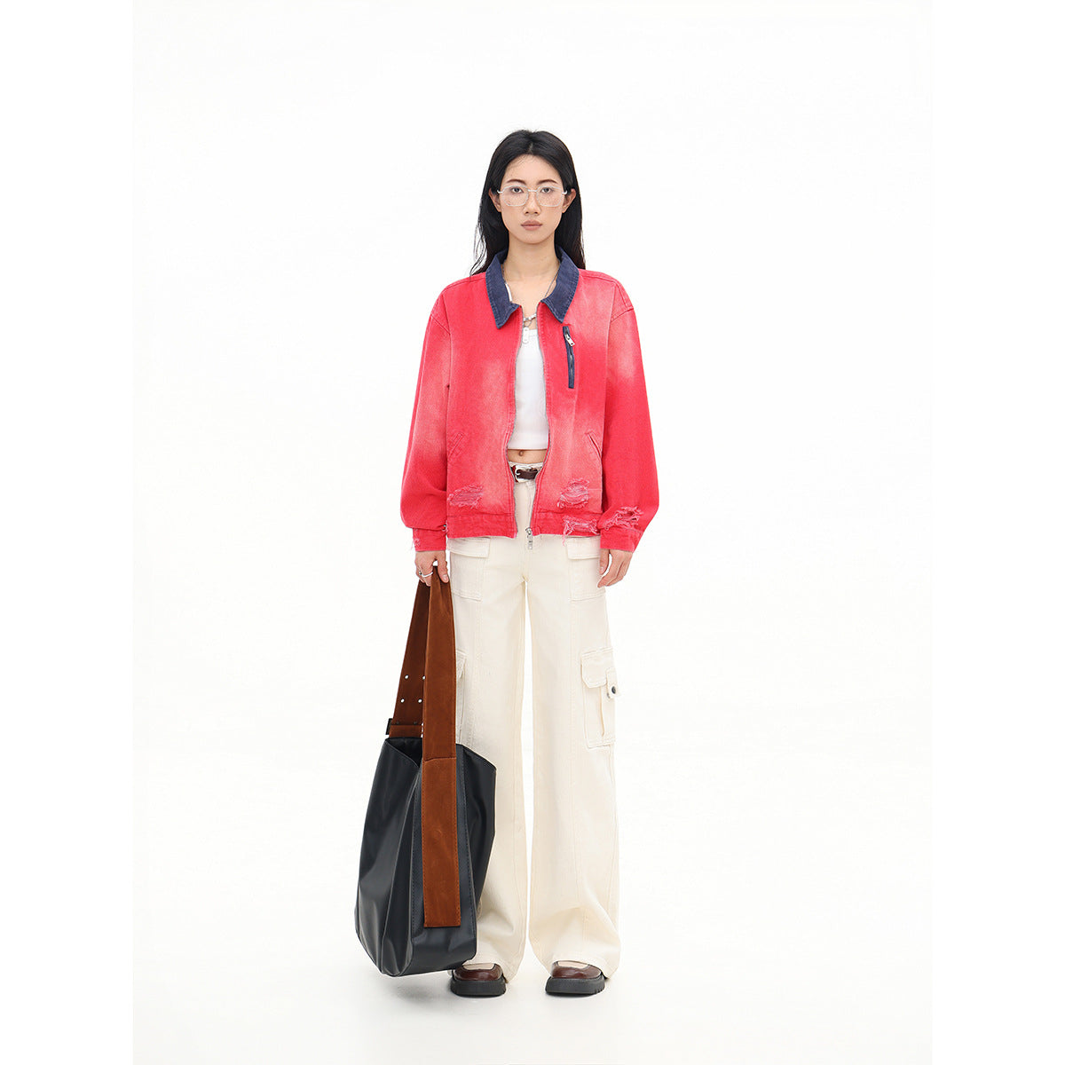 Front view of a model wearing a coral-red jacket with a dark blue collar and cream cargo pants.