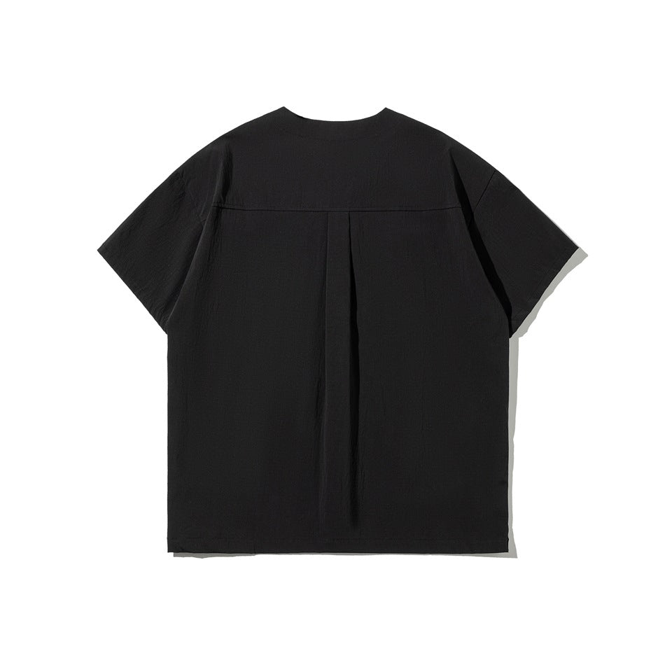 Back view of black short-sleeve shirt with yoke seam and center pleat, flat lay