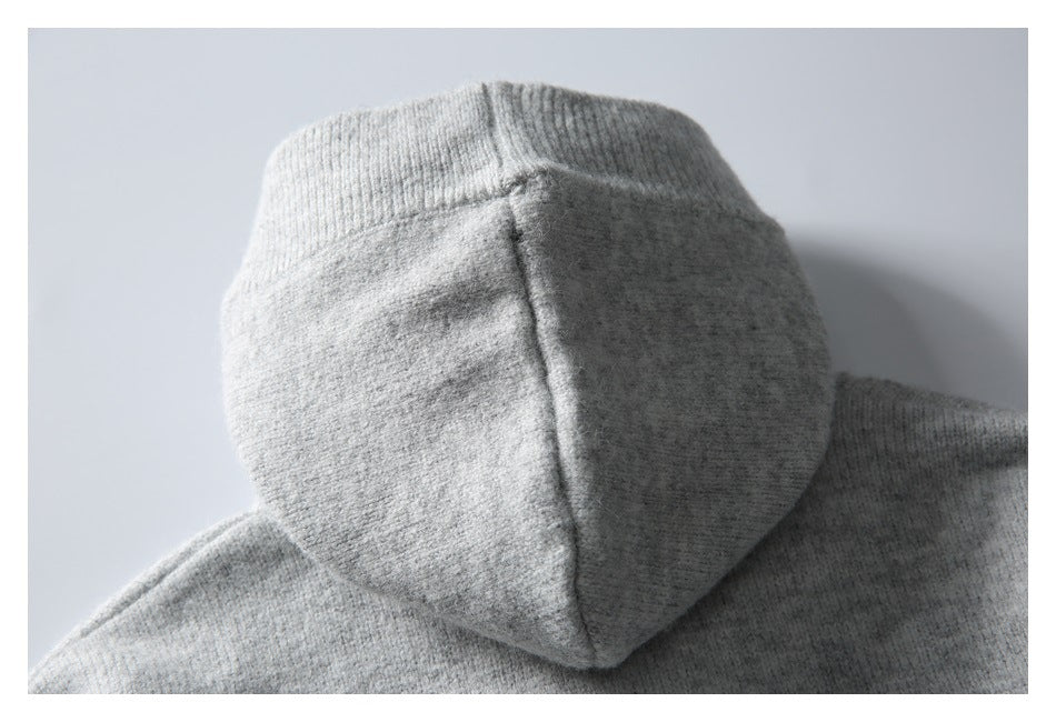 Close-up of the hood and ribbed edge on a light gray garment.