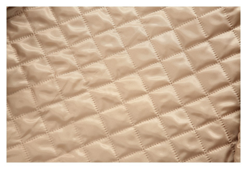 Close-up of shiny beige lining with a diamond-quilted stitch pattern.