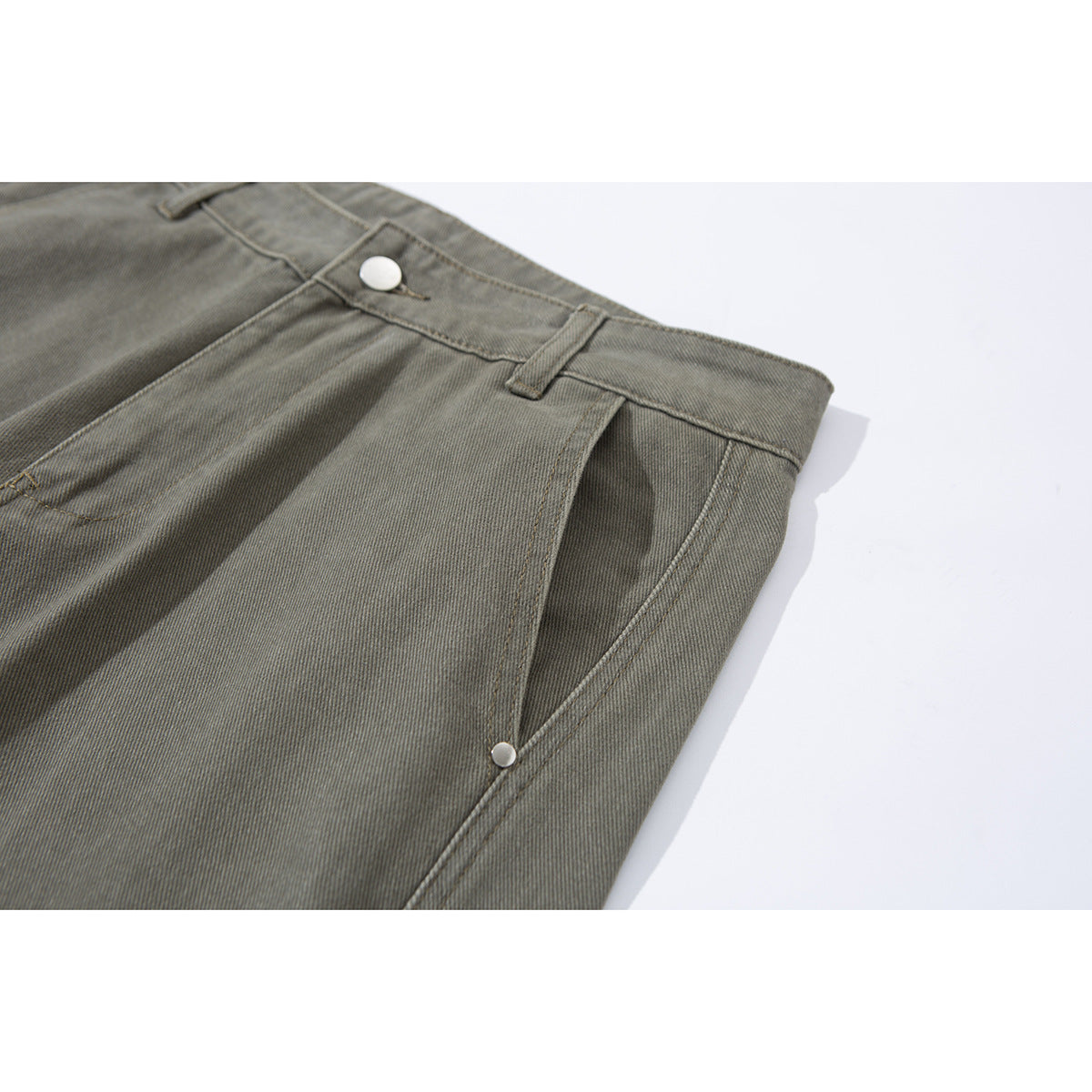Angled close-up of olive-gray pants showing the waistband, button, belt loop, and side pocket opening.