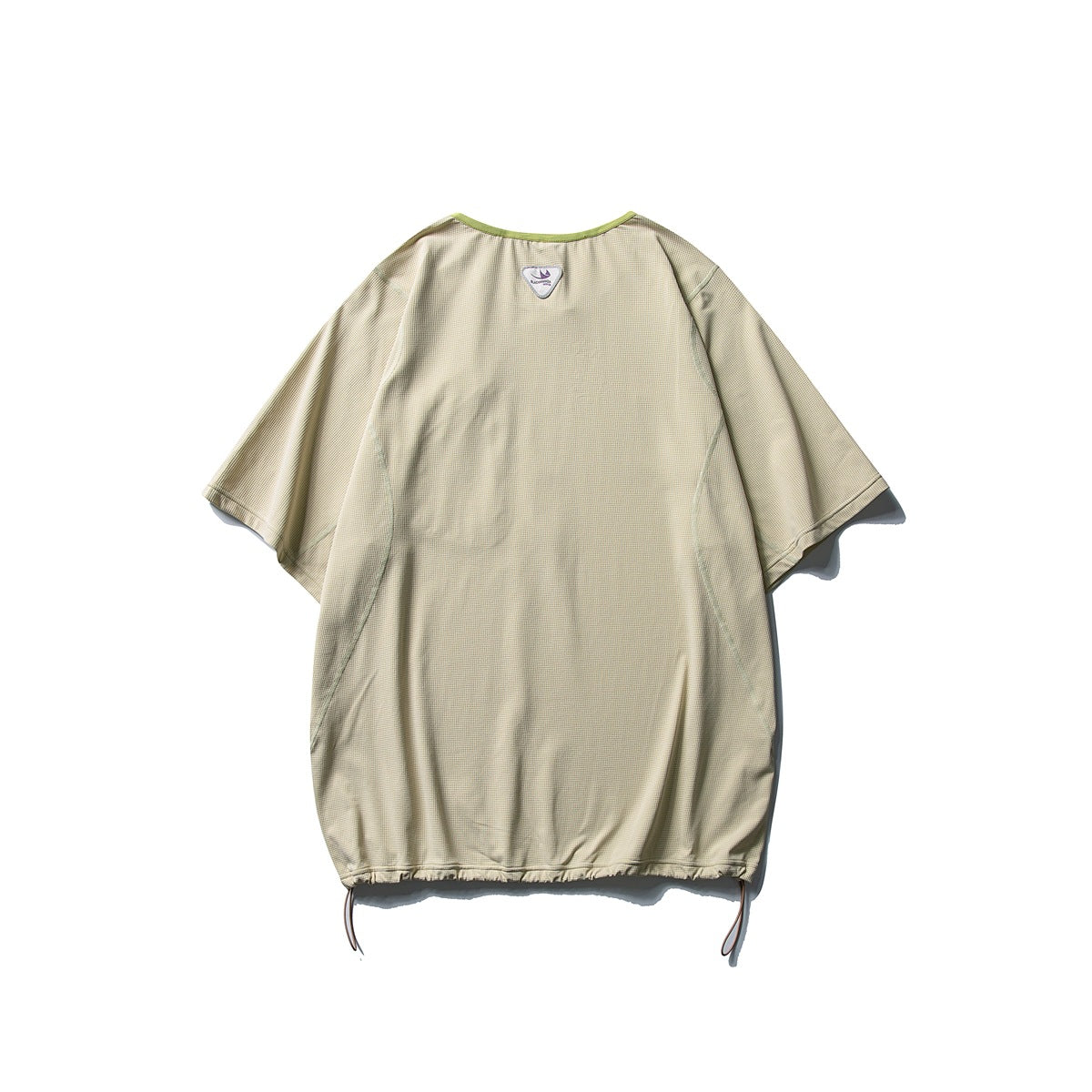 Back view of a beige oversized short-sleeve shirt with green neckline trim and adjustable drawstrings at the hem.