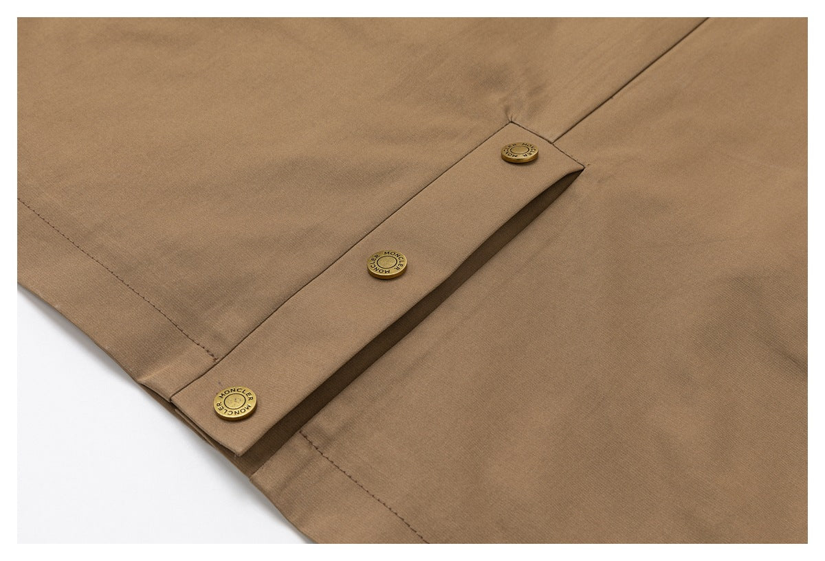 Close-up of the tan jacket front placket with three brass buttons and stitched seams.