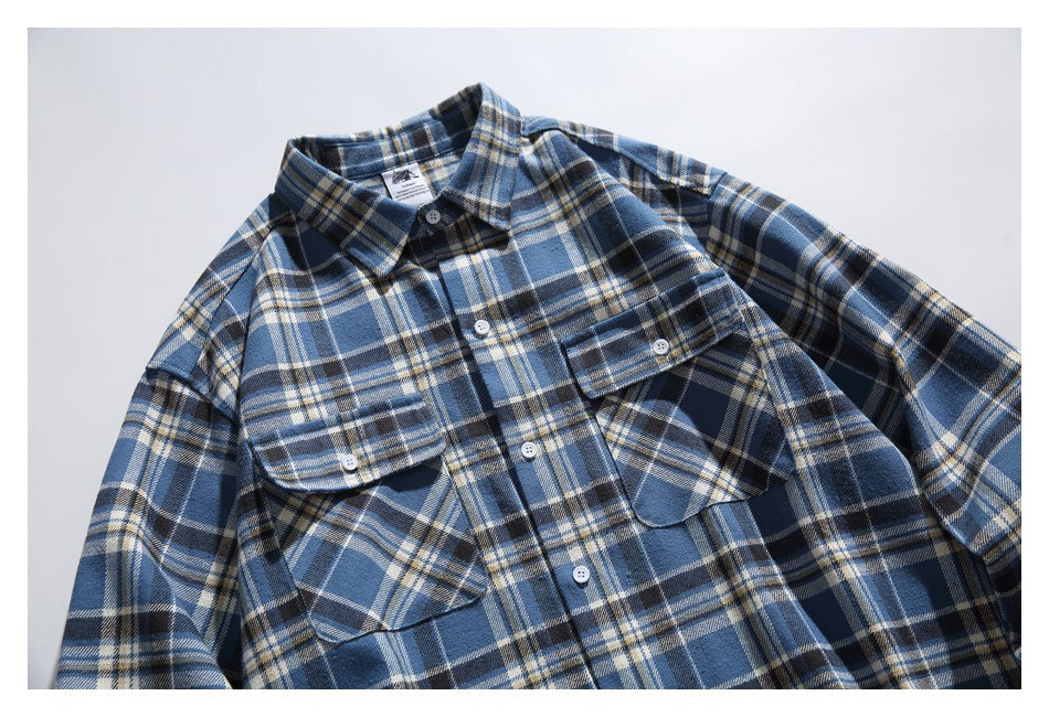 Front view of a blue, navy, and cream plaid shirt with a button front, collar, and two flap chest pockets.
