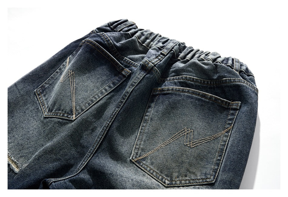 Rear upper section of dark washed jeans with an elastic waistband and two stitched back pockets.