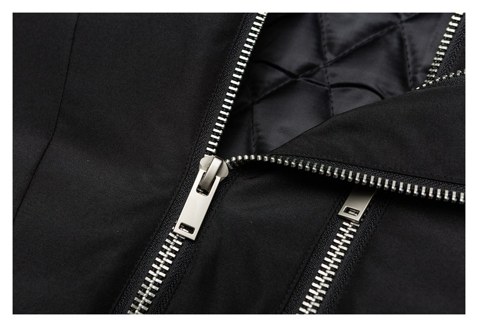 Close-up of an open silver zipper on a black jacket, showing quilted lining.
