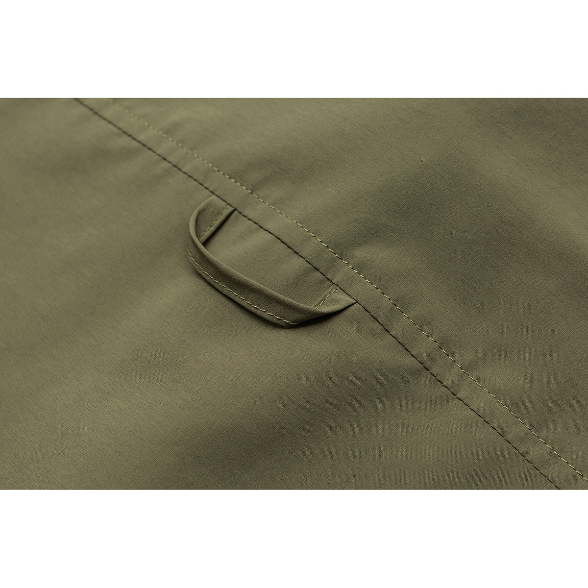 Close-up of olive fabric with a stitched seam and a small fabric loop.