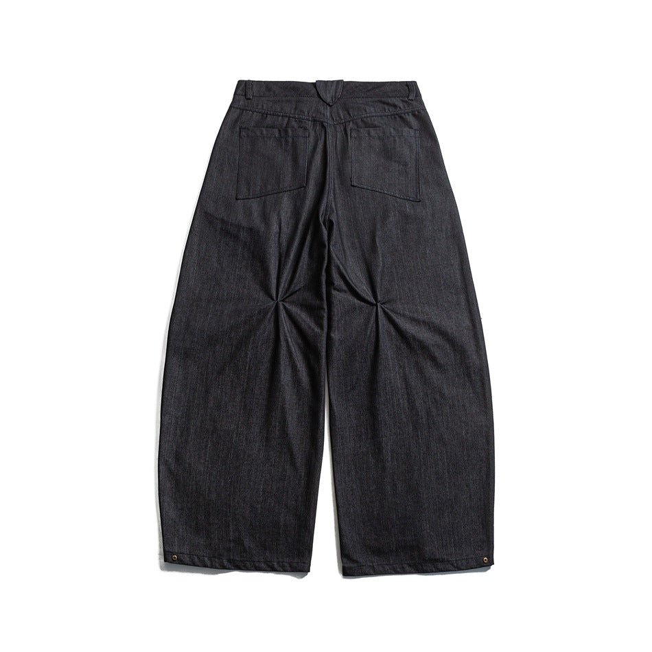 Back view of dark charcoal wide-leg trousers laid flat, with two rear pockets and small ankle rivets.