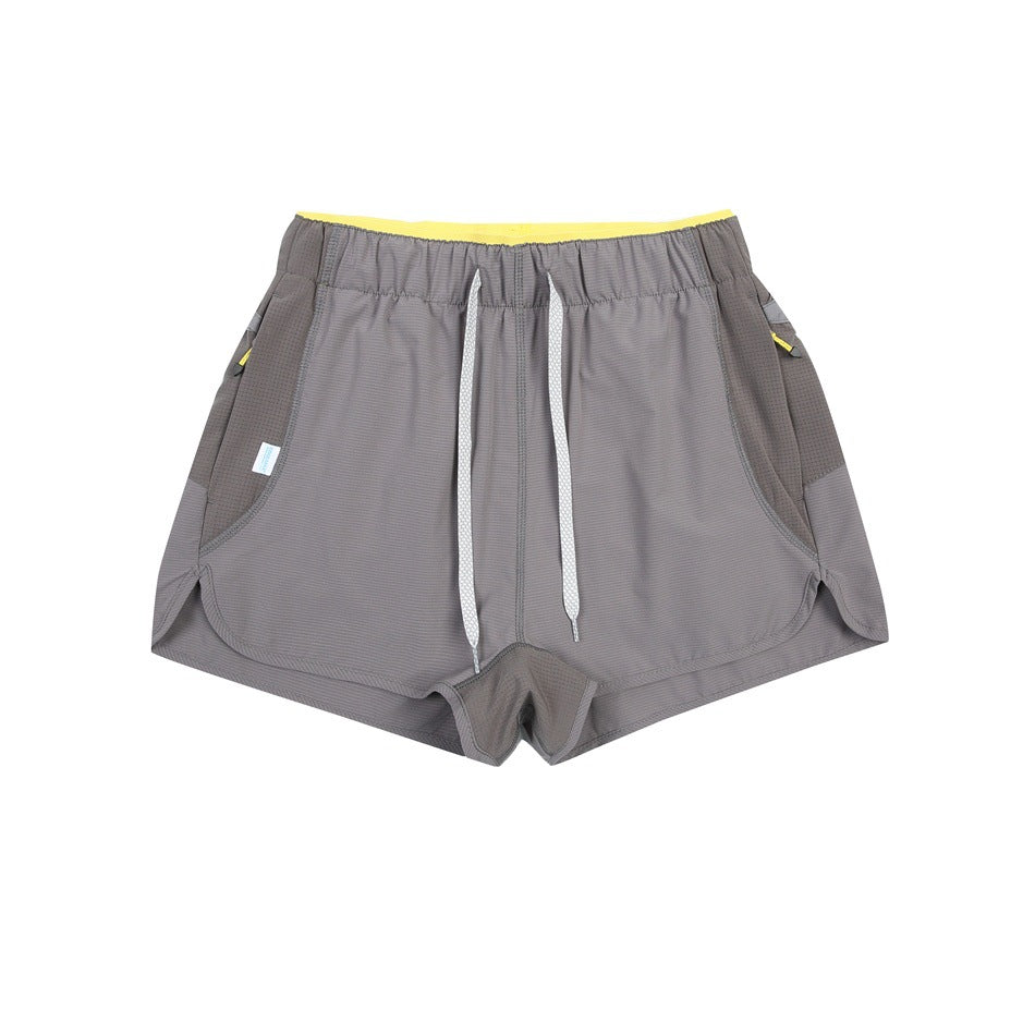Gray shorts with white drawstring, darker gray side panels and a yellow inner waistband, flat lay