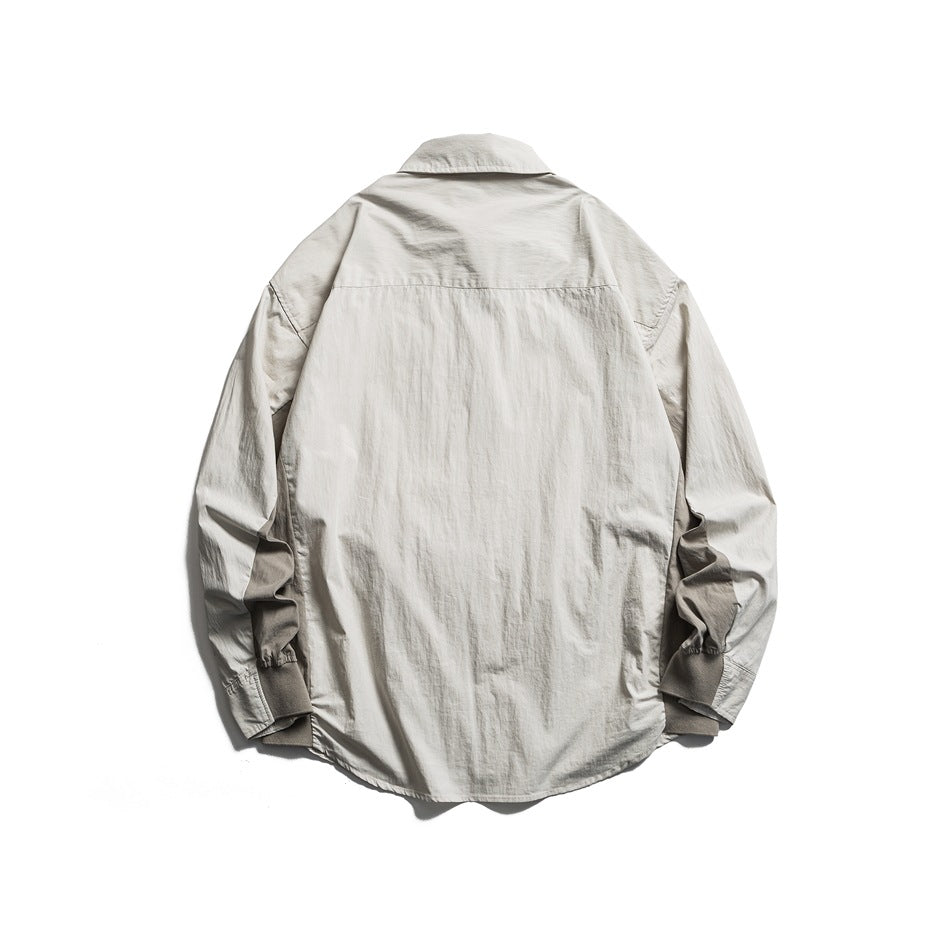 Beige button-up shirt back view with back yoke seam and darker underarm panels, flat lay