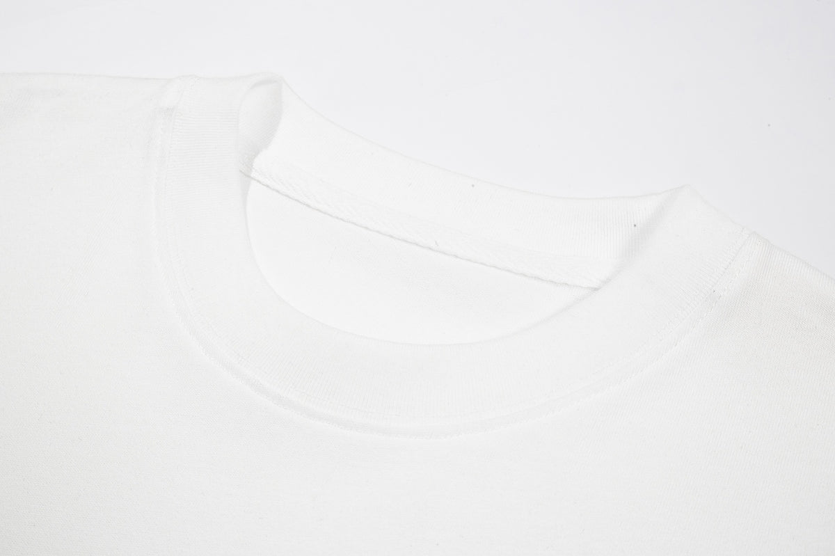 Close-up of a white T-shirt's ribbed crew neck, inner stitching, and shoulder seams.