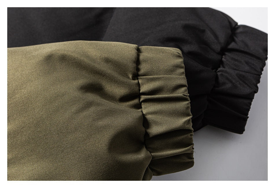 Close-up of gathered elastic cuffs on olive and black padded jacket sleeves.