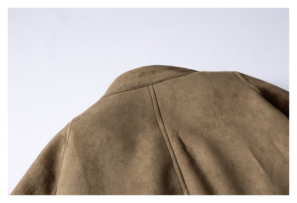 Close-up of the back shoulder and collar of a taupe-brown jacket, with a vertical center seam.