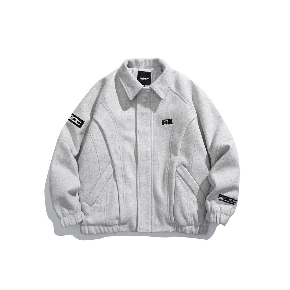 Front view of a light gray jacket with a pointed collar, zip closure, curved seams, angled pockets, elastic cuffs and hem