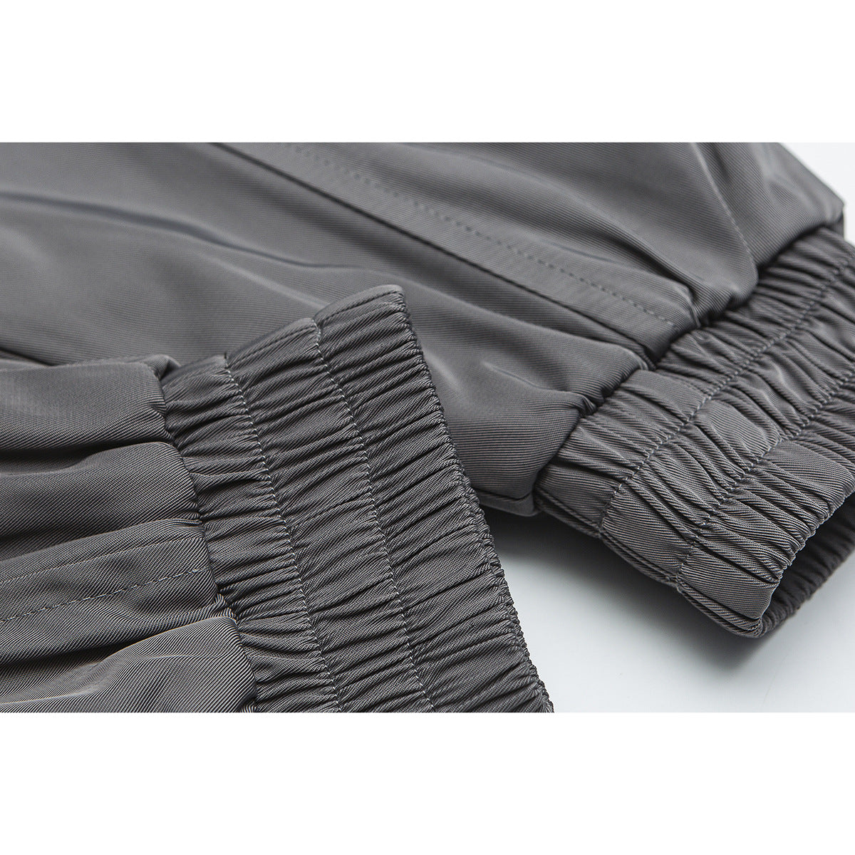 Close-up of a gray jacket's gathered elastic cuff and waistband.