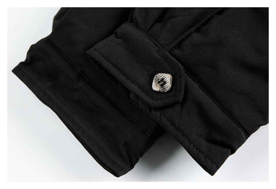 Close-up of a black jacket cuff with a light patterned button and stitched edges.