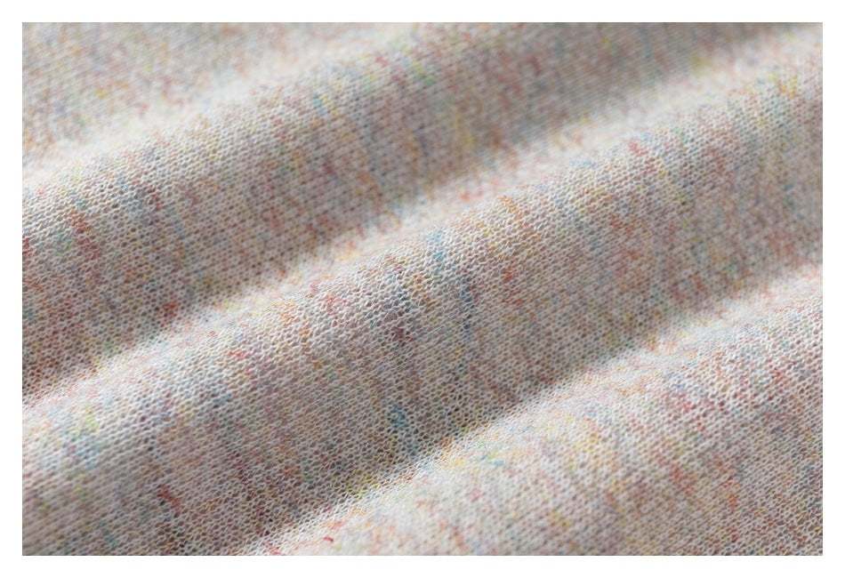 Extreme close-up showing the soft-looking, pale multicolor heathered knit texture.