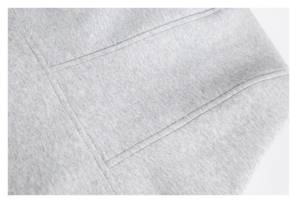 Close-up of heather-gray fabric with parallel stitched seams forming a panel.
